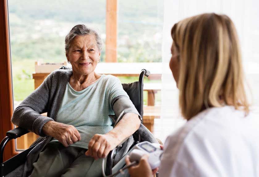 A caregiver visiting with a senior in their home.